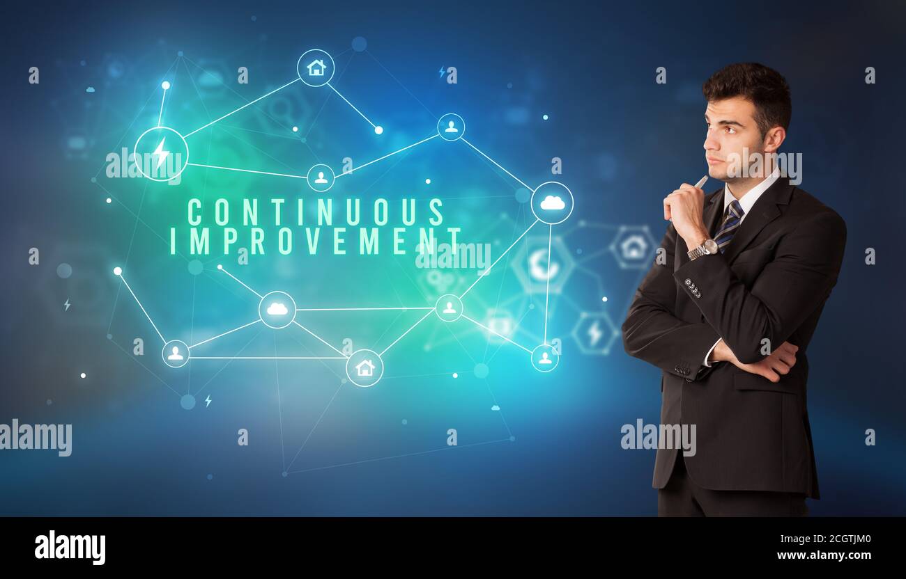 Businessman in front of cloud service icons with CONTINUOUS IMPROVEMENT ...
