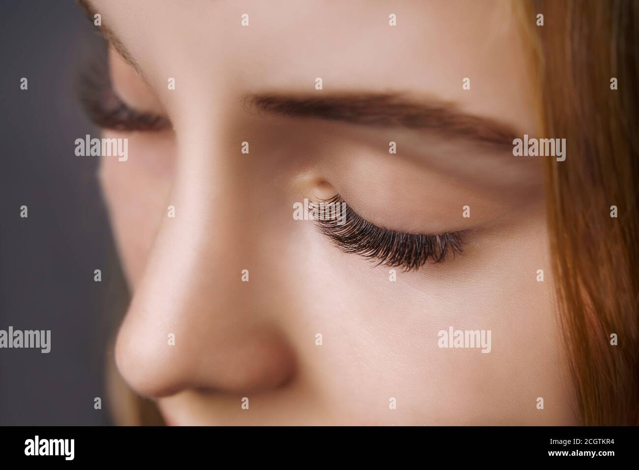 Eyelash Extension Procedure. Woman Eye with Long Eyelashes. Close up, selective focus. Stock Photo