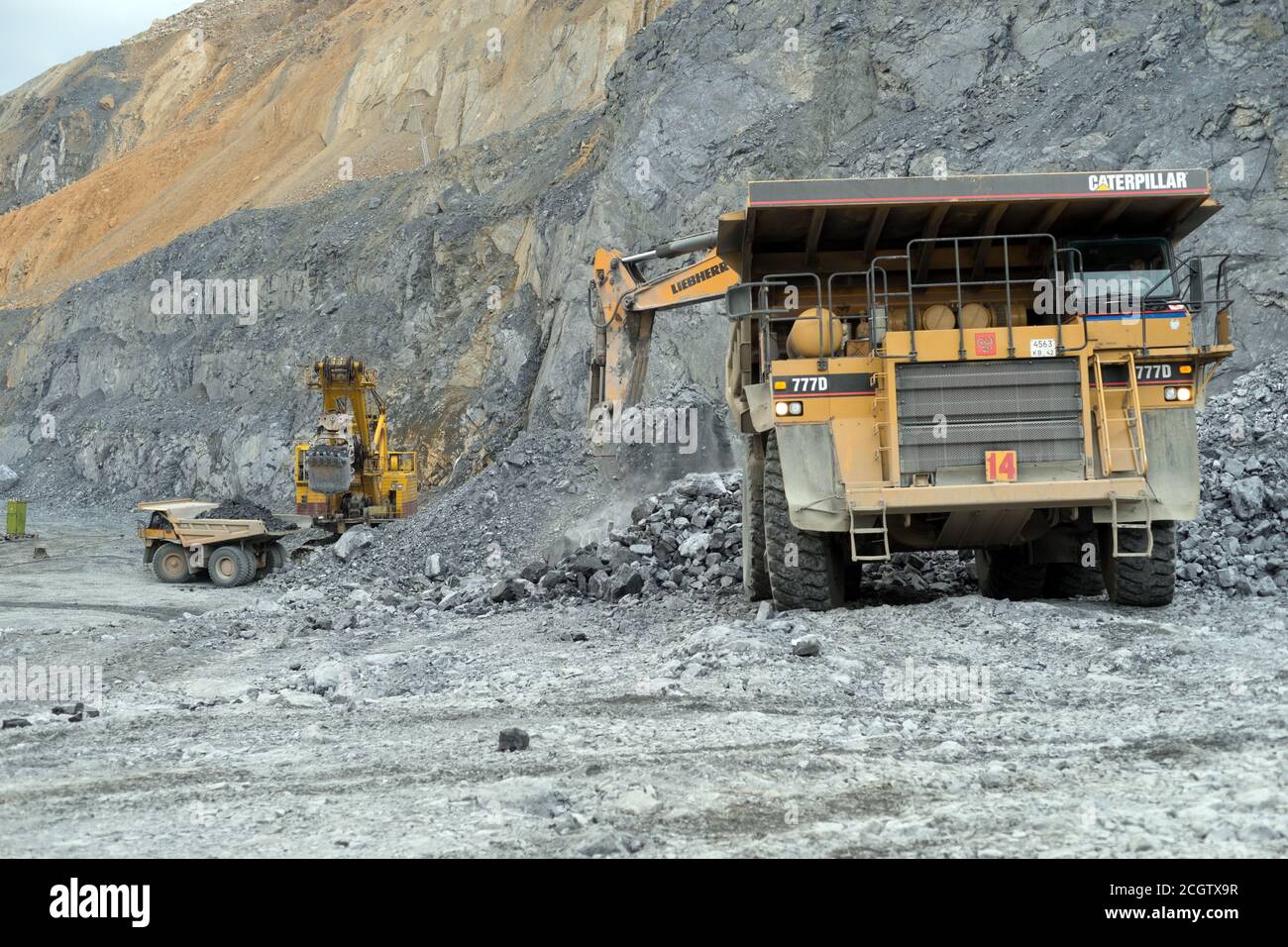 Nephson Dig Rig Excavators pour nepheline ore into dump trucks of Caterpillar in a ...