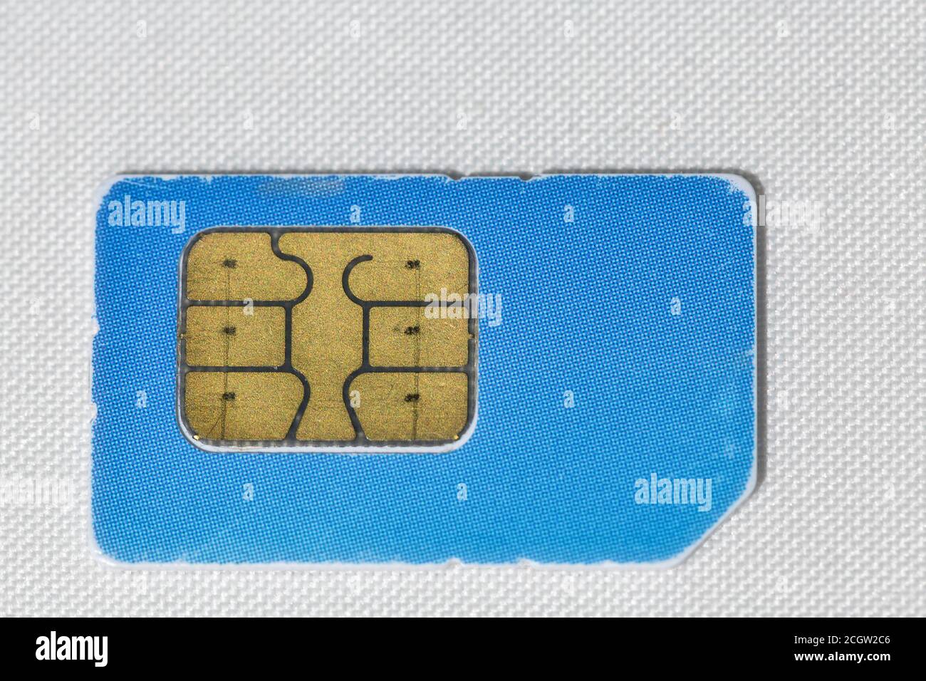 used scratched blue mobile phone sim card macro on white Stock Photo