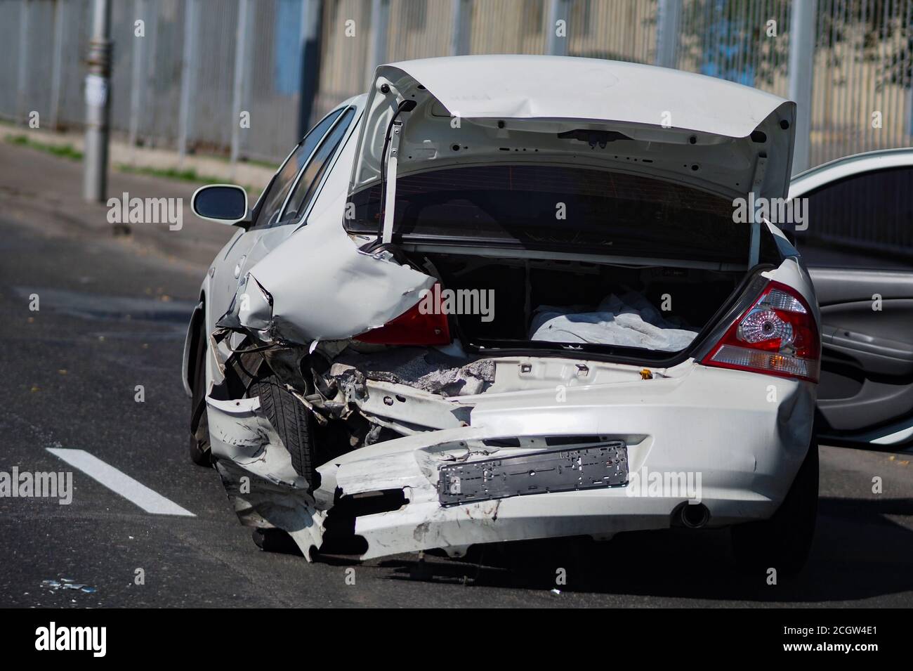 White passenger car crashed in an accident stands in the middle of the ...
