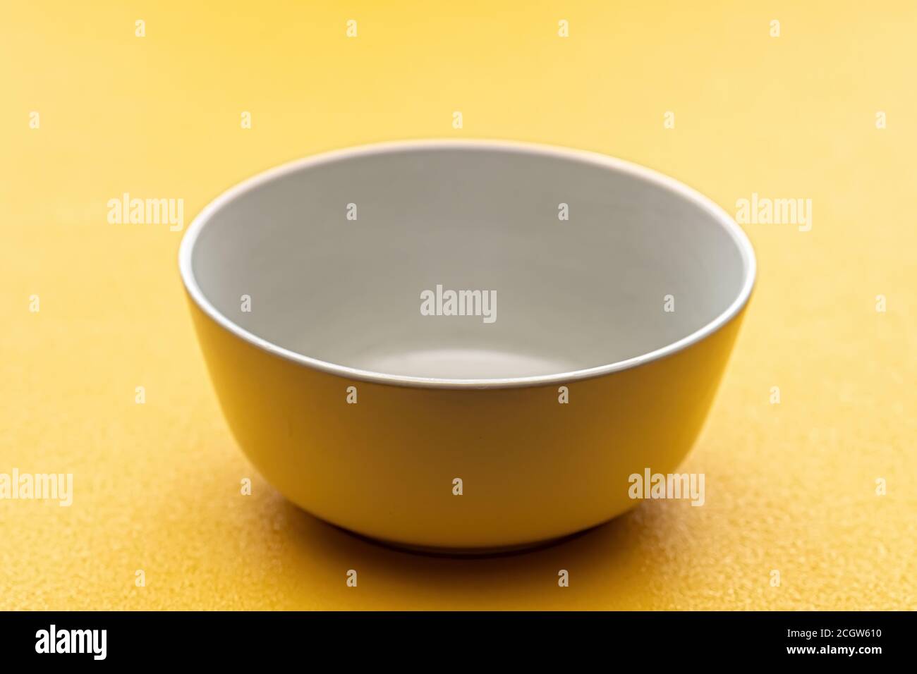 Empty white Cup on a yellow background, isolate. Stock Photo