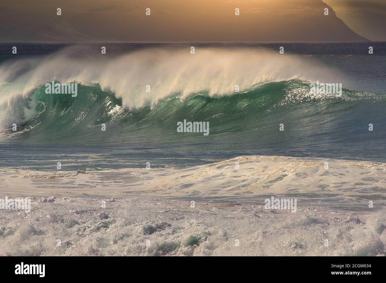 Massive breaking wave at sunset on Oahu at north shore. Stock Photo