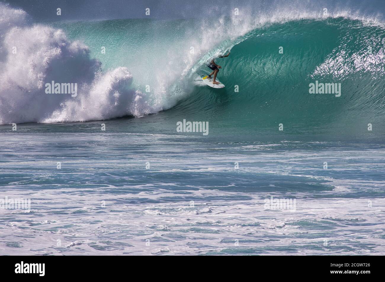 Unrecognizable surfer deep in the curl of a massive North shore oahu wave. Stock Photo