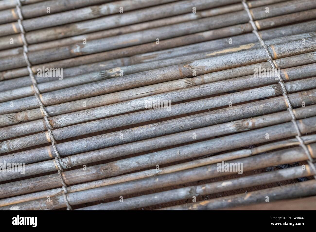 Close shot of flat section of natural reed garden screening, showing traces of reed decay. Nice natural texture background or metaphor for gardening. Stock Photo