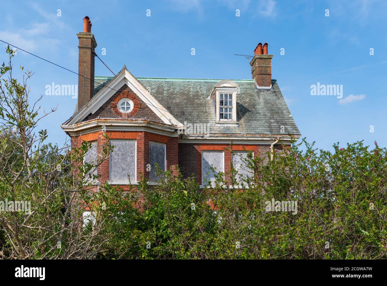 Derelict remains with boarded up windows of Neo-Caroline style outhouse on grounds of Rustington Convalescent Home in West Sussex, England, UK. Stock Photo