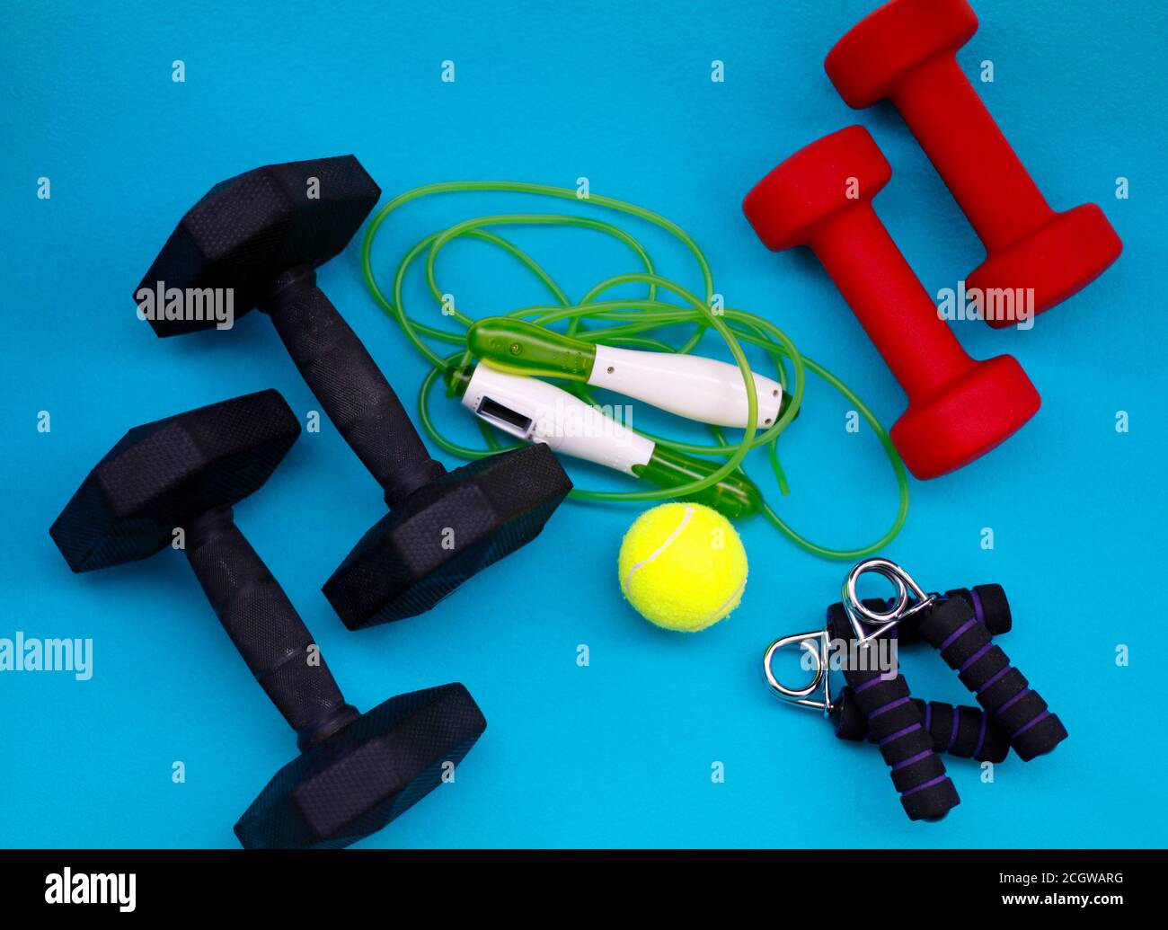 Exercise equipment. Weights, jump rope, tennis ball, hand grip strengthener Stock Photo
