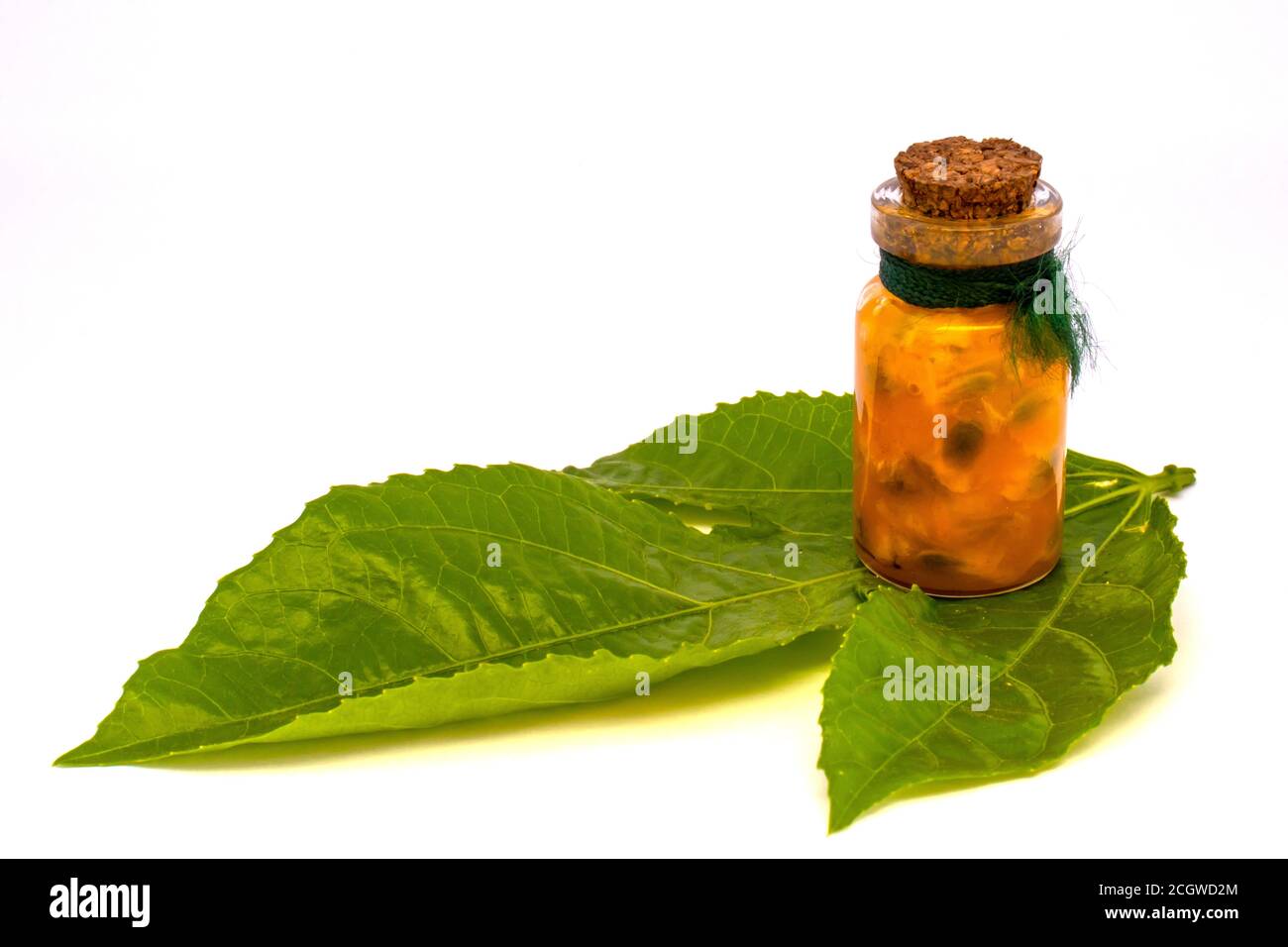 Maracuja cut in half in the bottle and flask and whole with leaf on wooden background. Passion fruit with fruit juice and seeds. Stock Photo