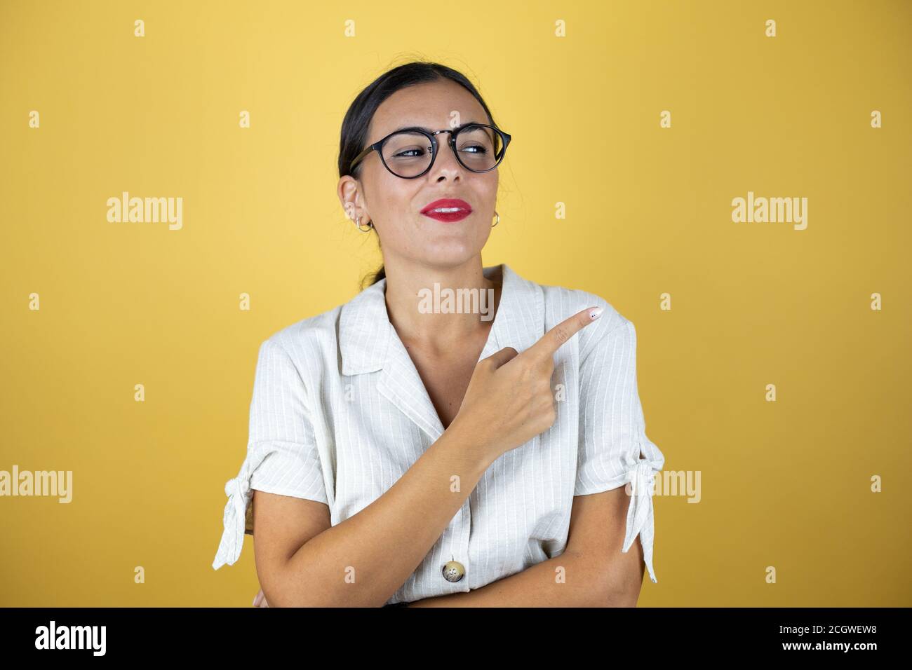 Beautiful woman over yellow background smiling happy pointing with hand ...