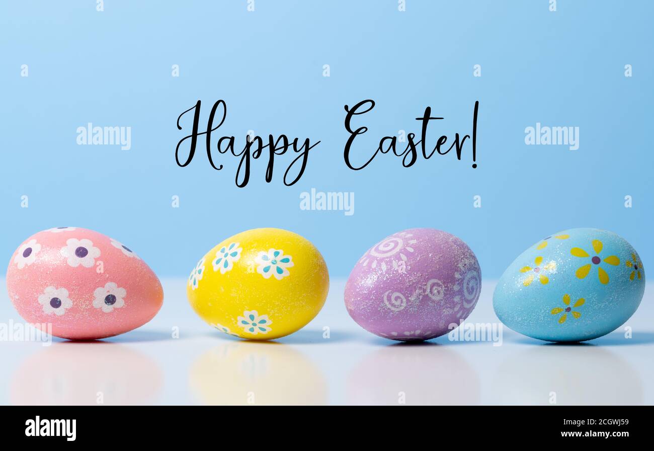 Colorful Easter eggs on blue background with greeting  Stock Photo