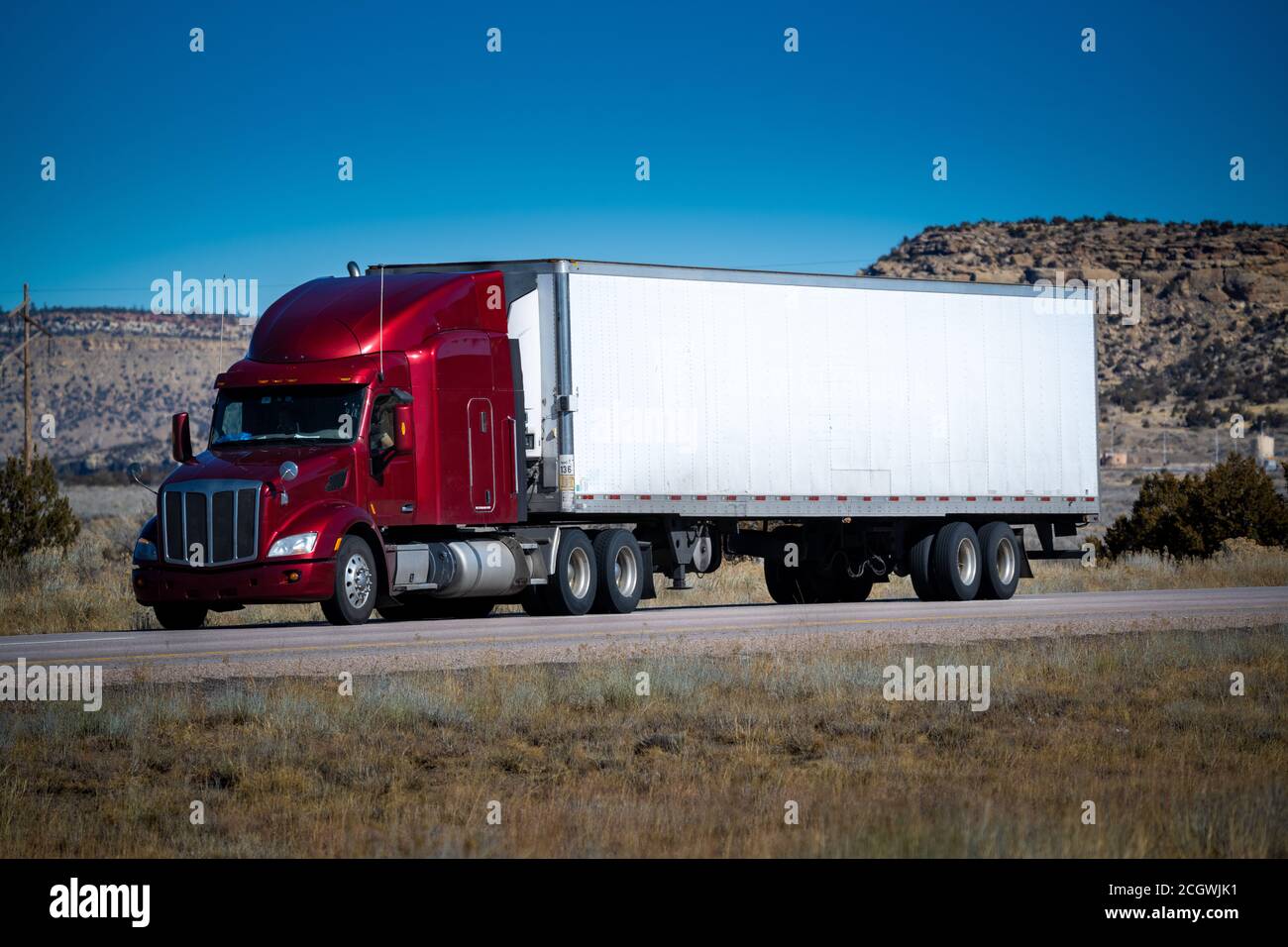 Eighteen wheel big rig tractor with trailer on highway. Trucking industry Stock Photo