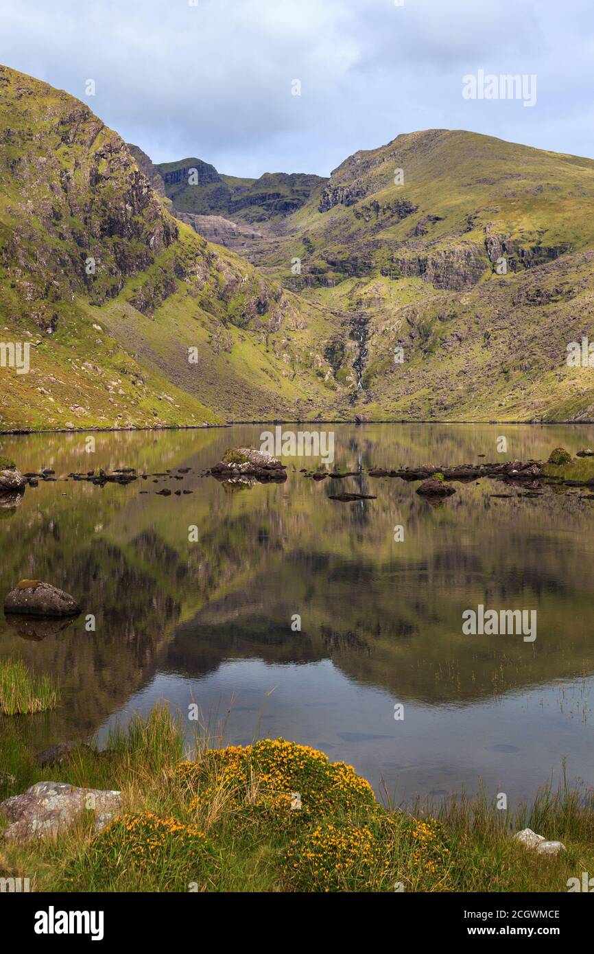 Looking Northwest along a calm Loch Cruite towards the Eastern Corrie below Brandon Mountain on the Dingle Peninsula in County Kerry, Ireland Stock Photo