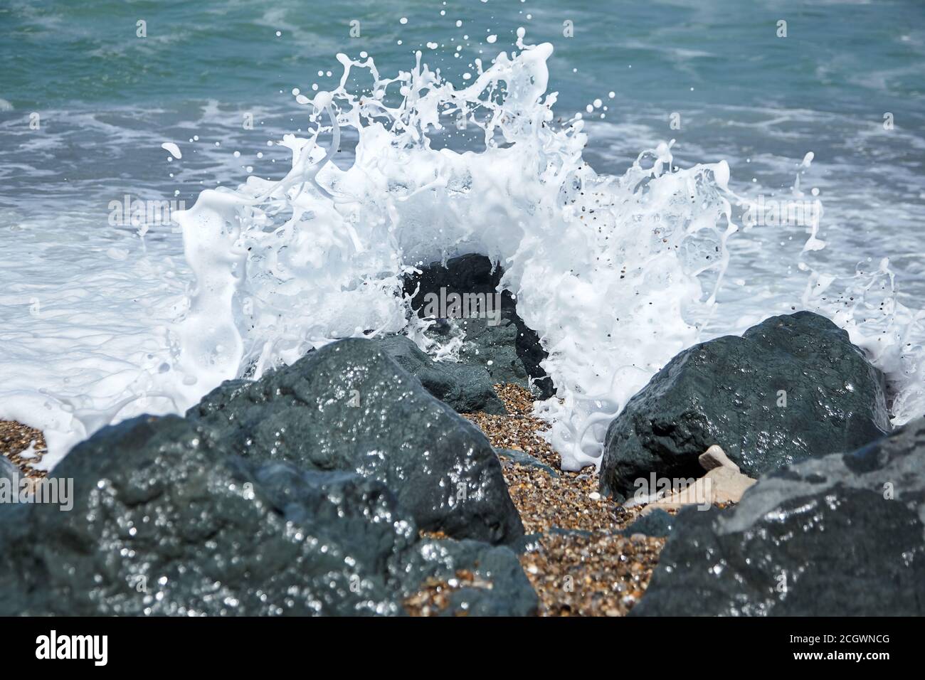 Sea wave crashing against a black stone with foam and splashes. Ocean ...