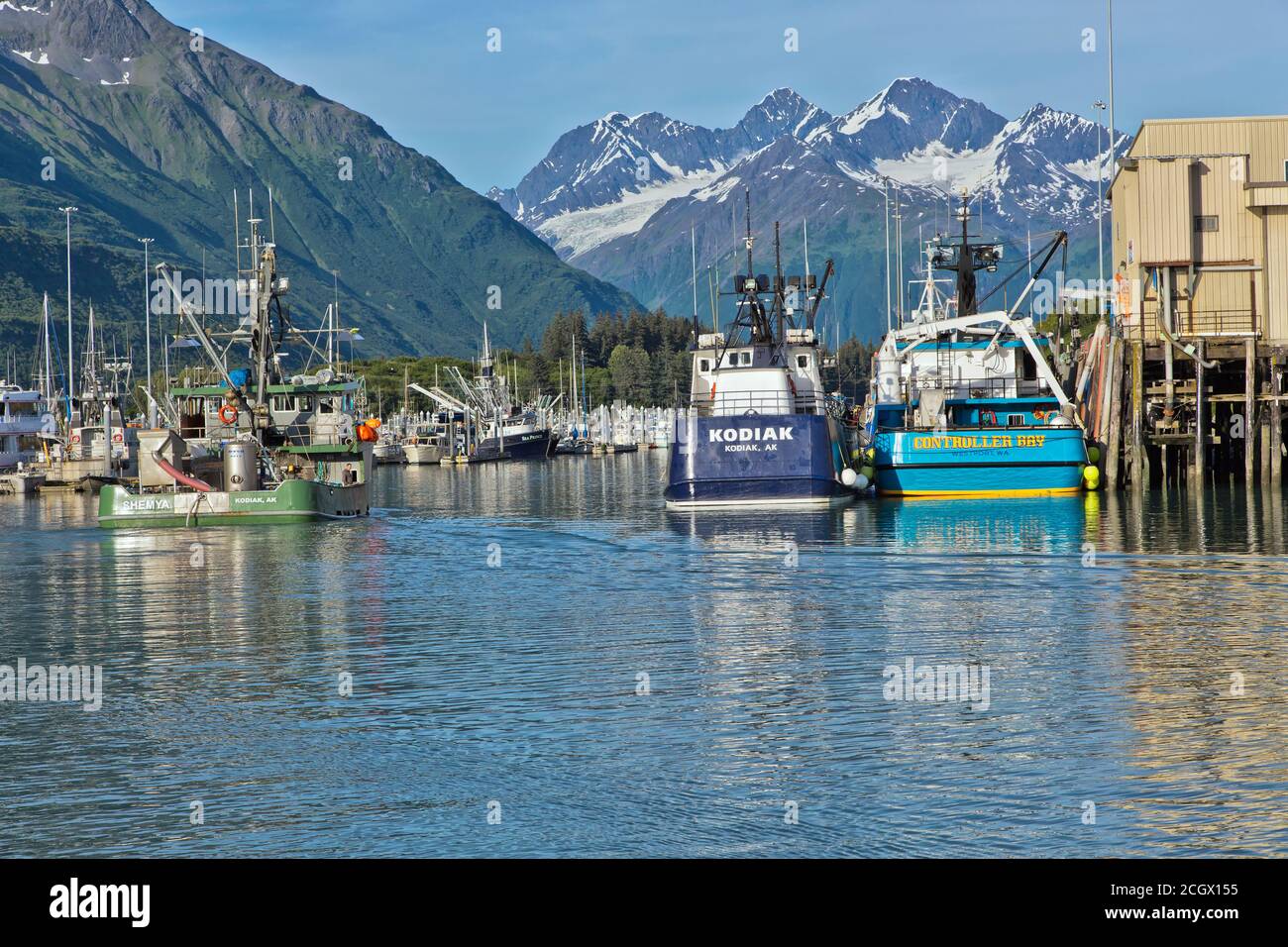 Fishing boats, Service Vessels moored, Port Of Valdez,  Anderson Glacier & Chugach Mountains in the distance. Stock Photo