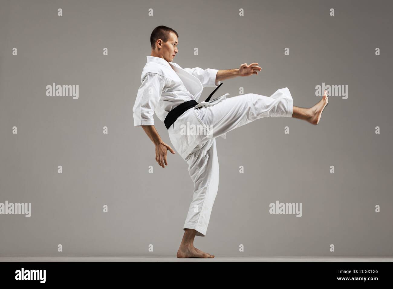 man exercising karate, against gray background Stock Photo