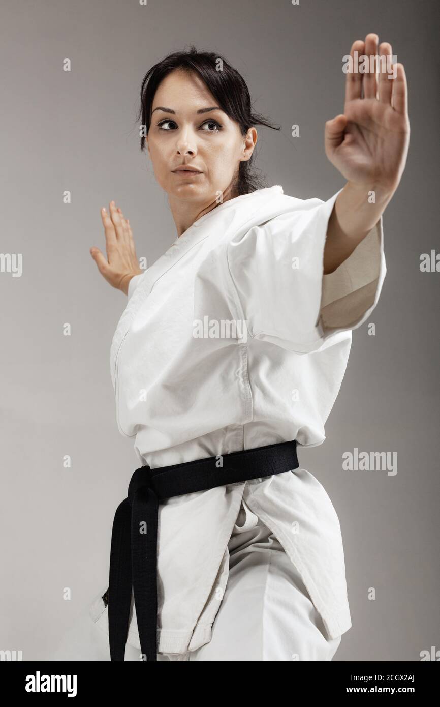 girl exercising karate, posing against gray background Stock Photo