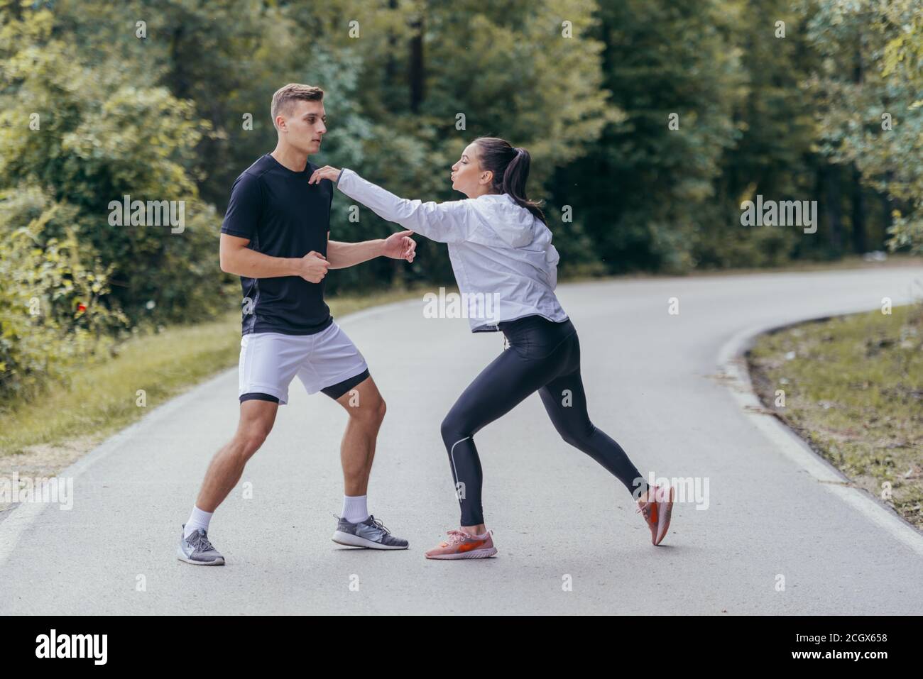 Young female defending herself from an attacher with karate moves. Stock Photo