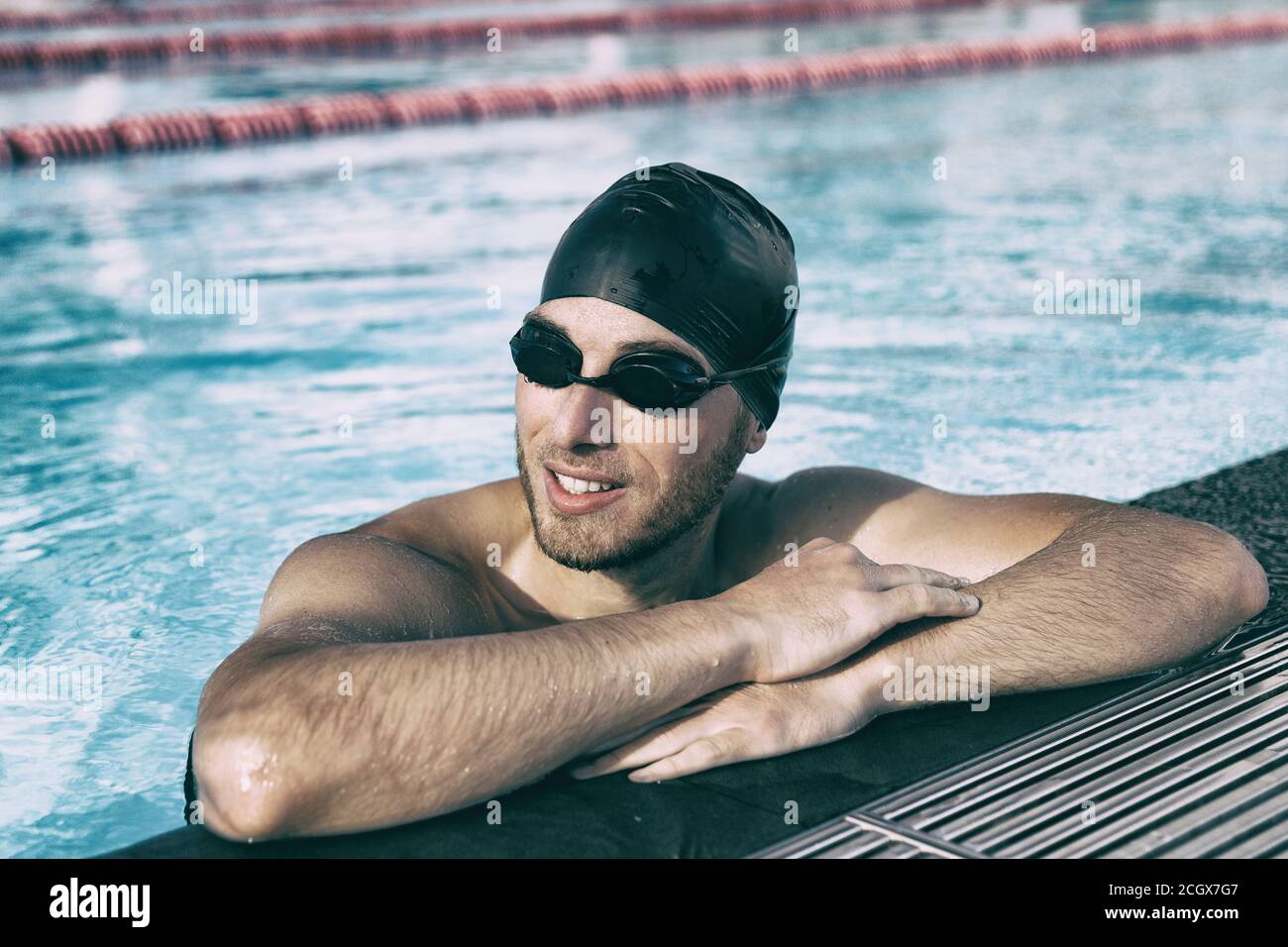 Swim athlete man wearing sport glasses and cap in indoor swimming pool Stock Photo