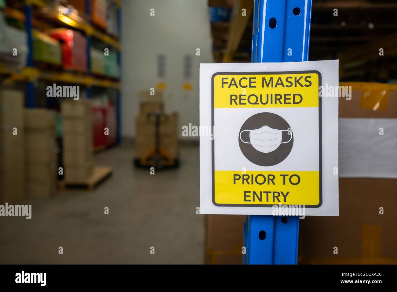 Sign caution in factory warning to industry labor worker to prevent Covid-19 Coronavirus spreading during job business reopening period after epidemic crisis . Working safely concept . Stock Photo