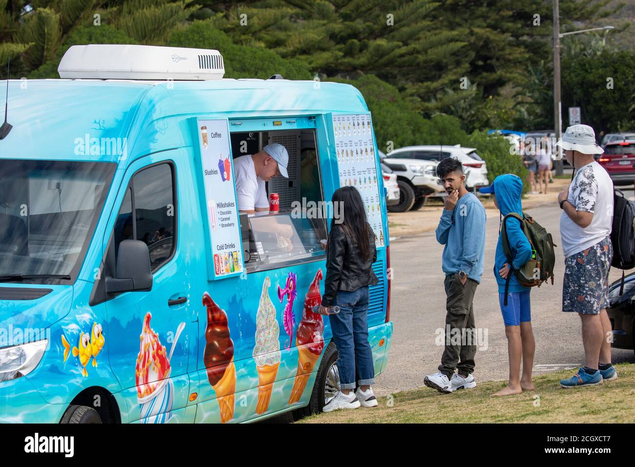 Traditional ice cream van and man selling lollies and ice creams Palm beach Sydney Australia