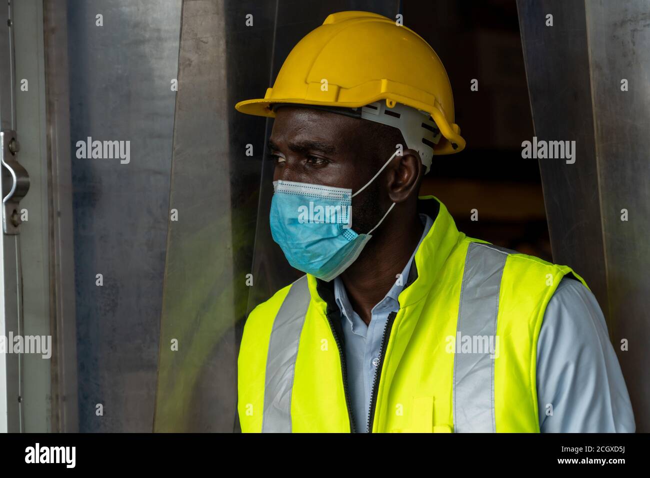 Factory industry worker working with face mask to prevent Covid-19 Coronavirus spreading during job reopening period . Stock Photo