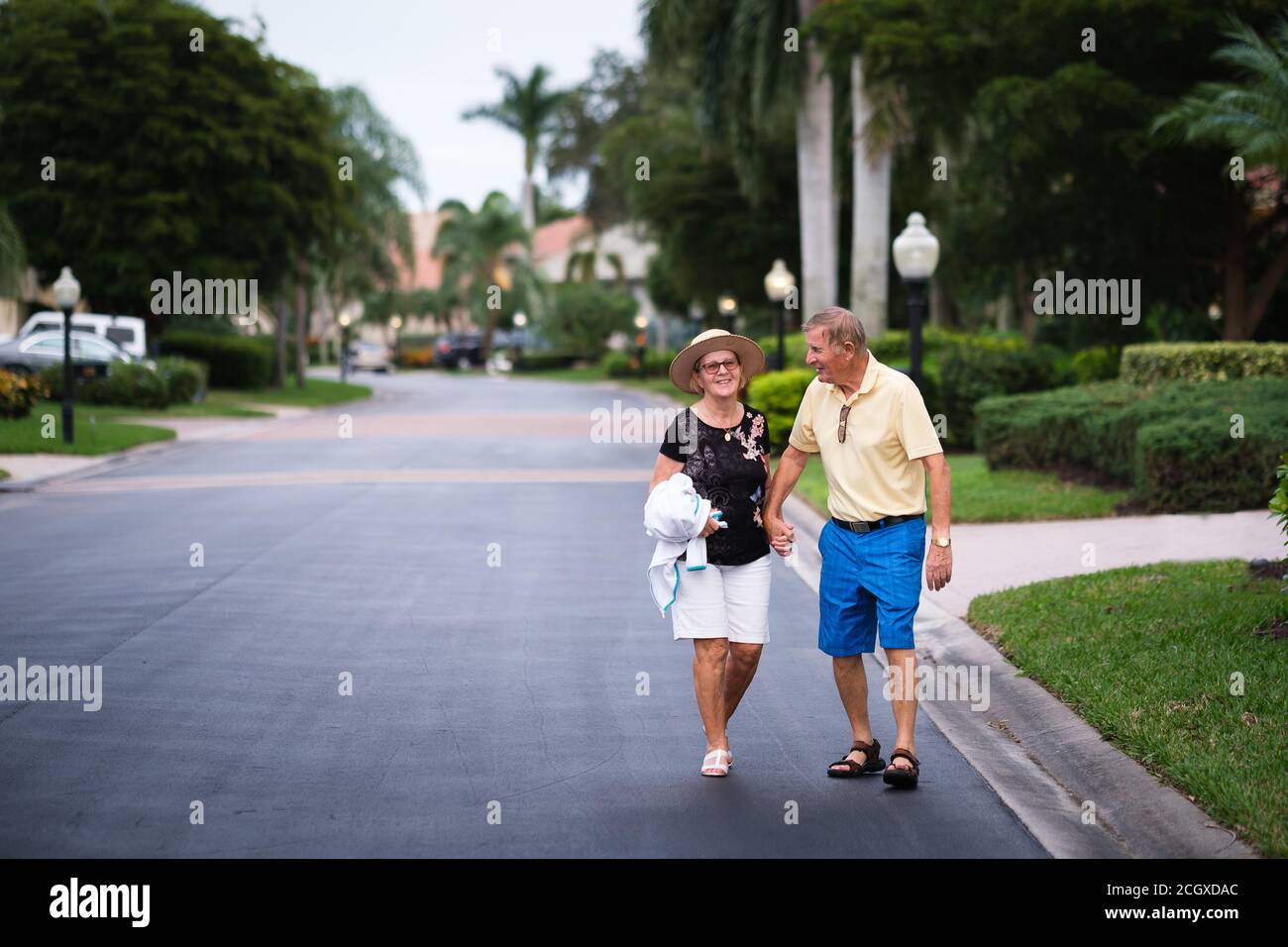 Elderly retired couple holding hands walking down a street Stock Photo ...