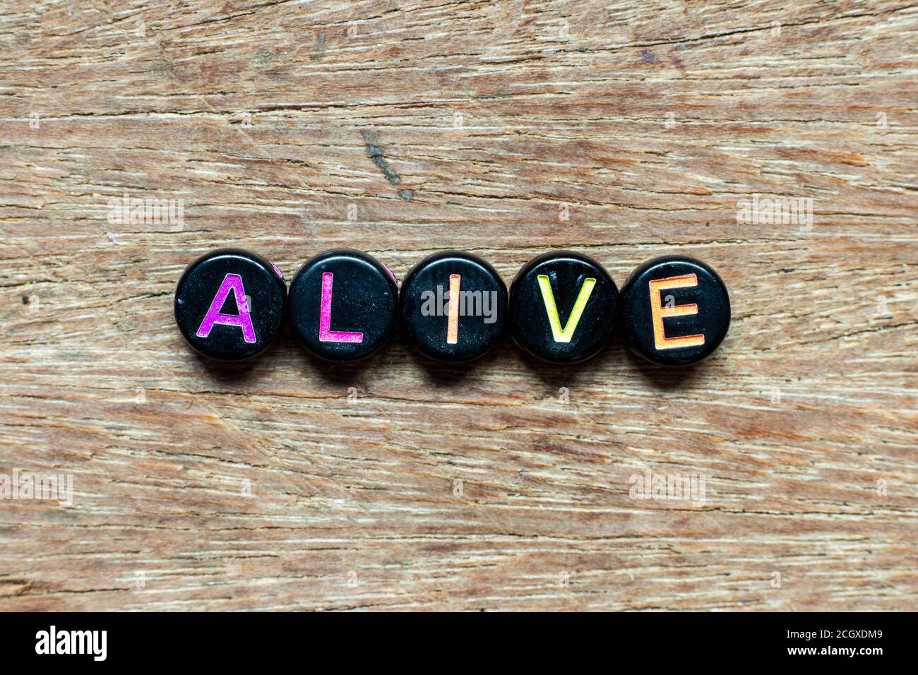 Black bead with color letter in word alive on wood background Stock ...