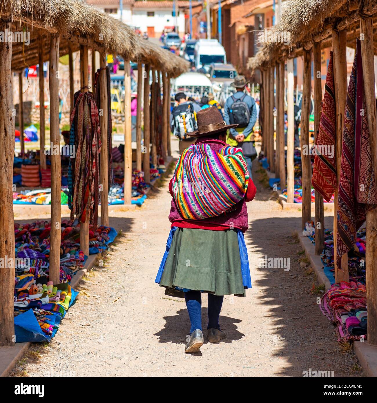 Peruvian indigenous Quechua woman with traditional textile walking on a fabric local market, Chinchero, Cusco province, Peru. Stock Photo