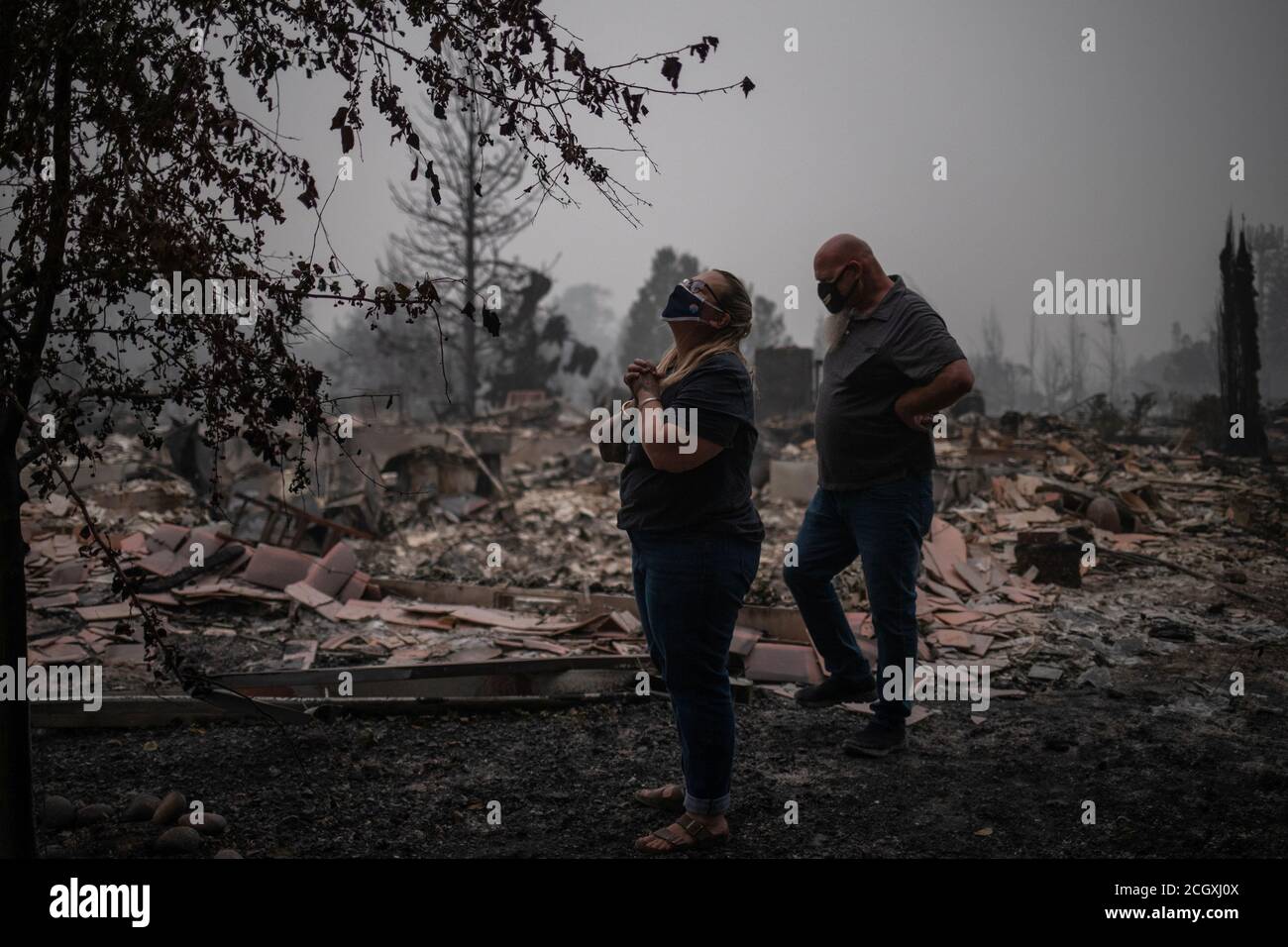 Tracy Koa puts her hands together in gratitude as she and her partner