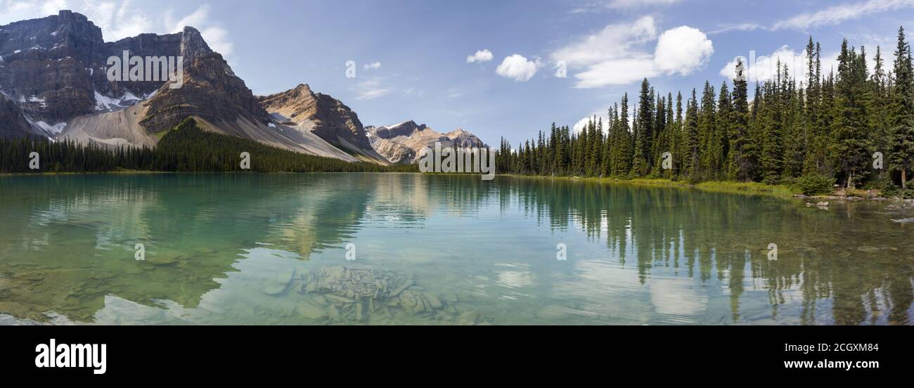 Wide Panoramic Landscape Treelined Scenic Bow Lake Water aRocky Mountain Peaks.  Summertime HIking Banff National Park, Alberta Canada Stock Photo