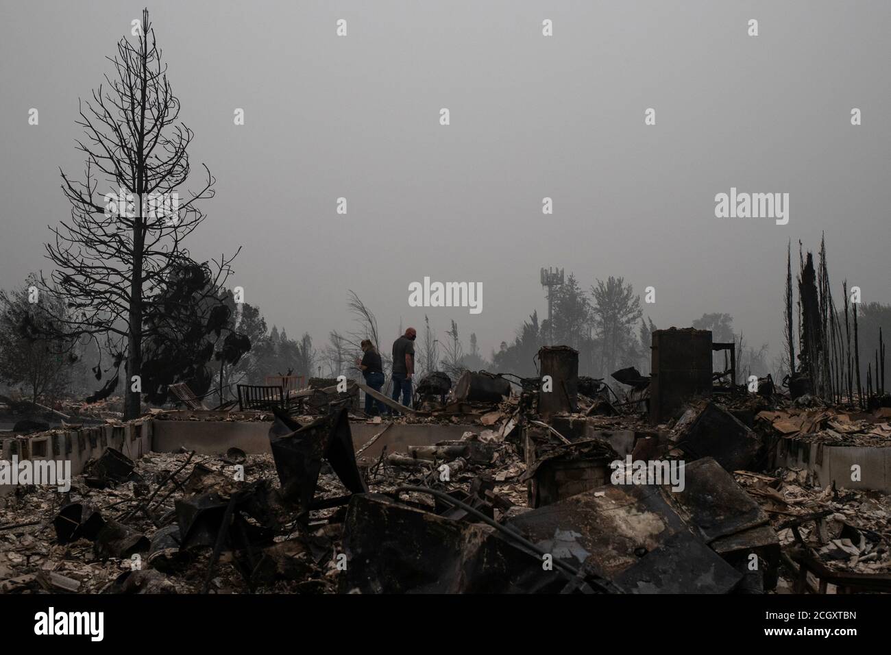 Tracy Koa and her partner David Tanksley survey the remains of their home gutted by the Almeda fire in Talent, Oregon, U.S., September 12, 2020. REUTERS/Adrees Latif Stock Photo