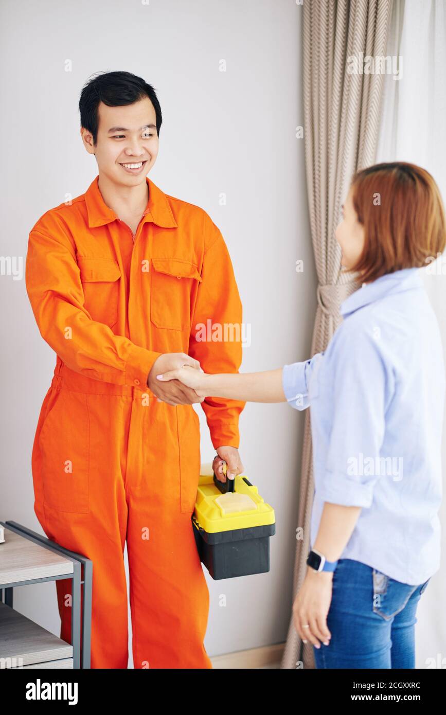 Technician and housewife shacking hands Stock Photo