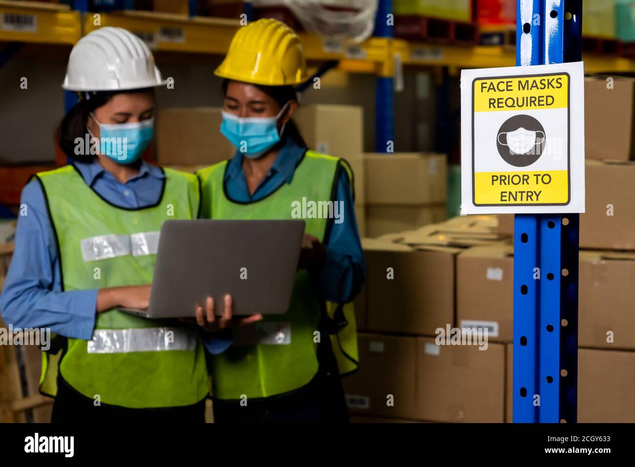Caution sign in factory warning to industry labor worker to prevent Covid-19 Coronavirus spreading during job business reopening period after epidemic crisis . Working safely concept . Stock Photo