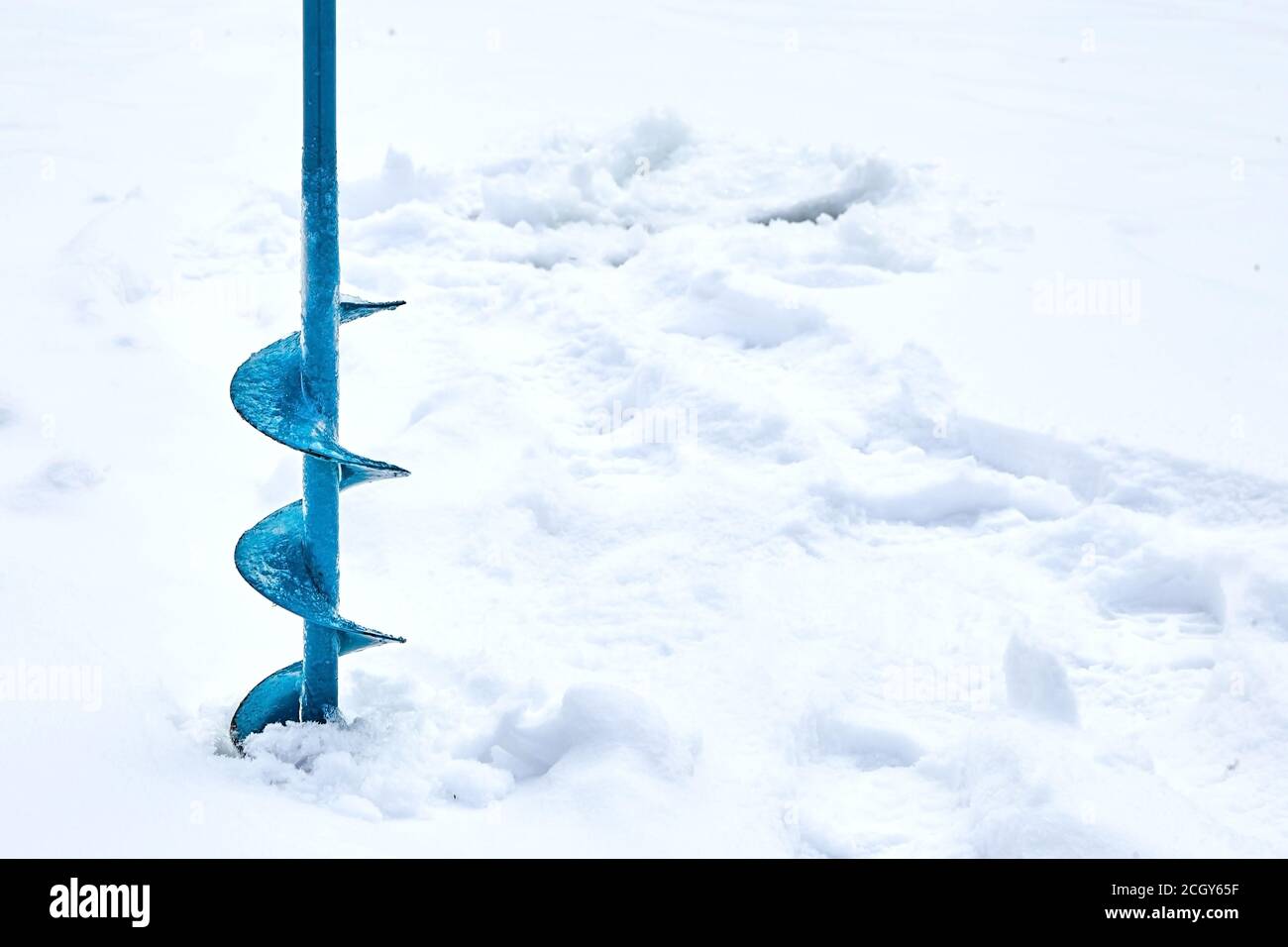 Hand operated ice auger used in ice fishing. Blue Metal Screw. Drill.  Hobbies, winter fishing on snowy lake Stock Photo - Alamy