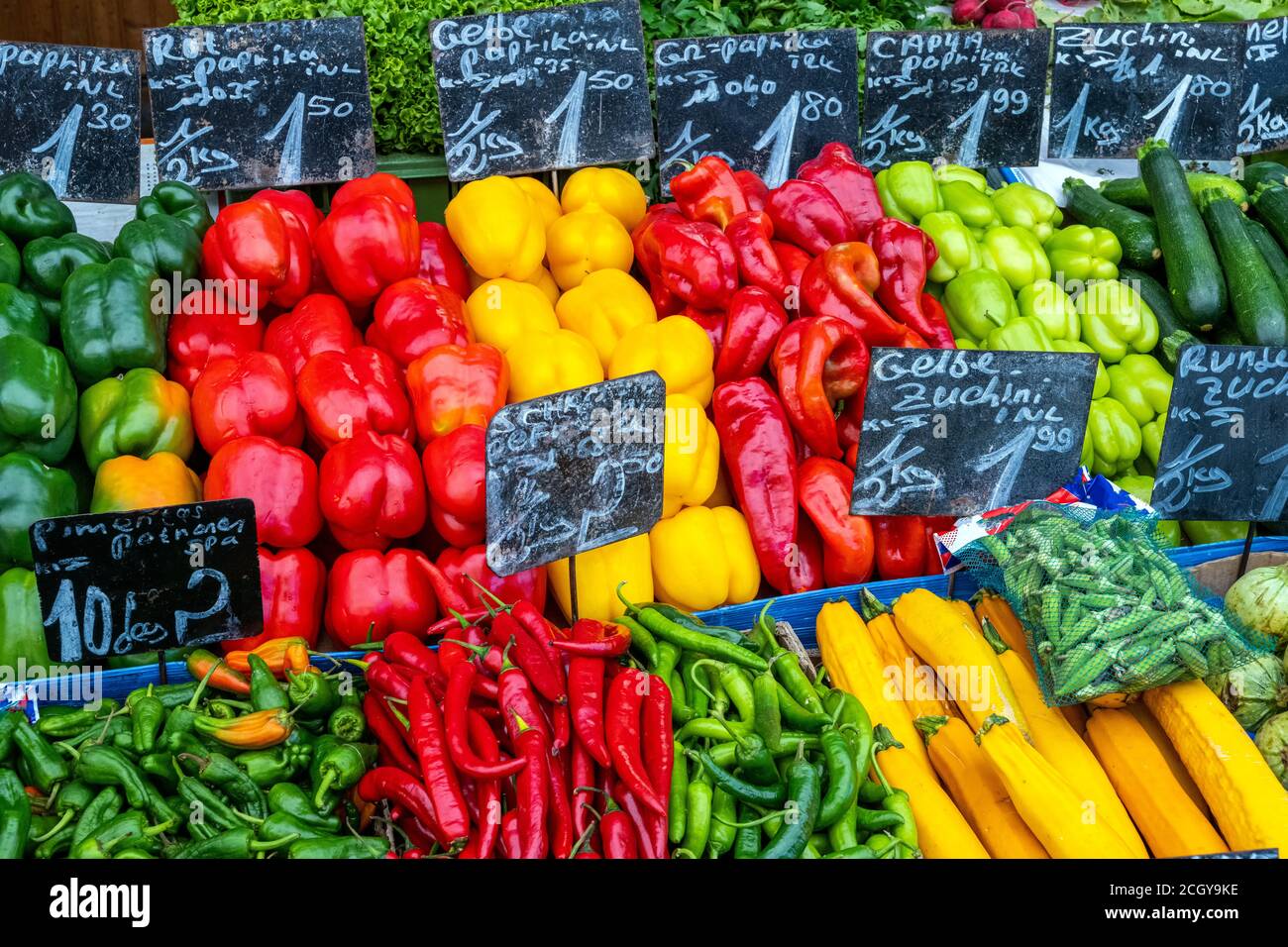 Different kind of peppers and other vegetables for sale at a market ...