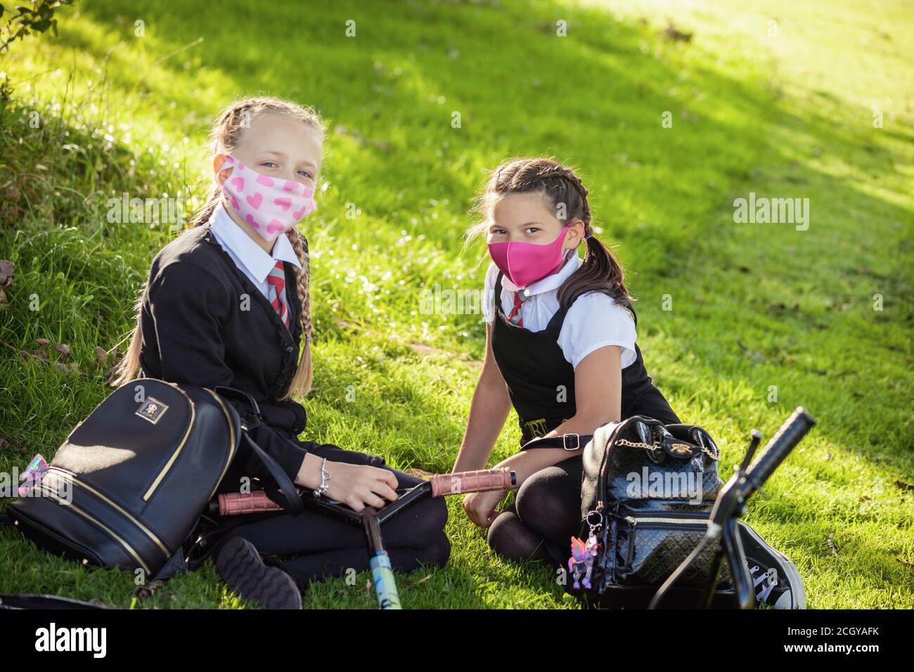 Two young school children wearing school uniform and face masks looking to camera, Scotland, UK Stock Photo