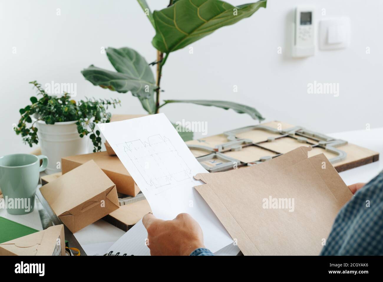 Box maker comparing template with a drawing Stock Photo - Alamy
