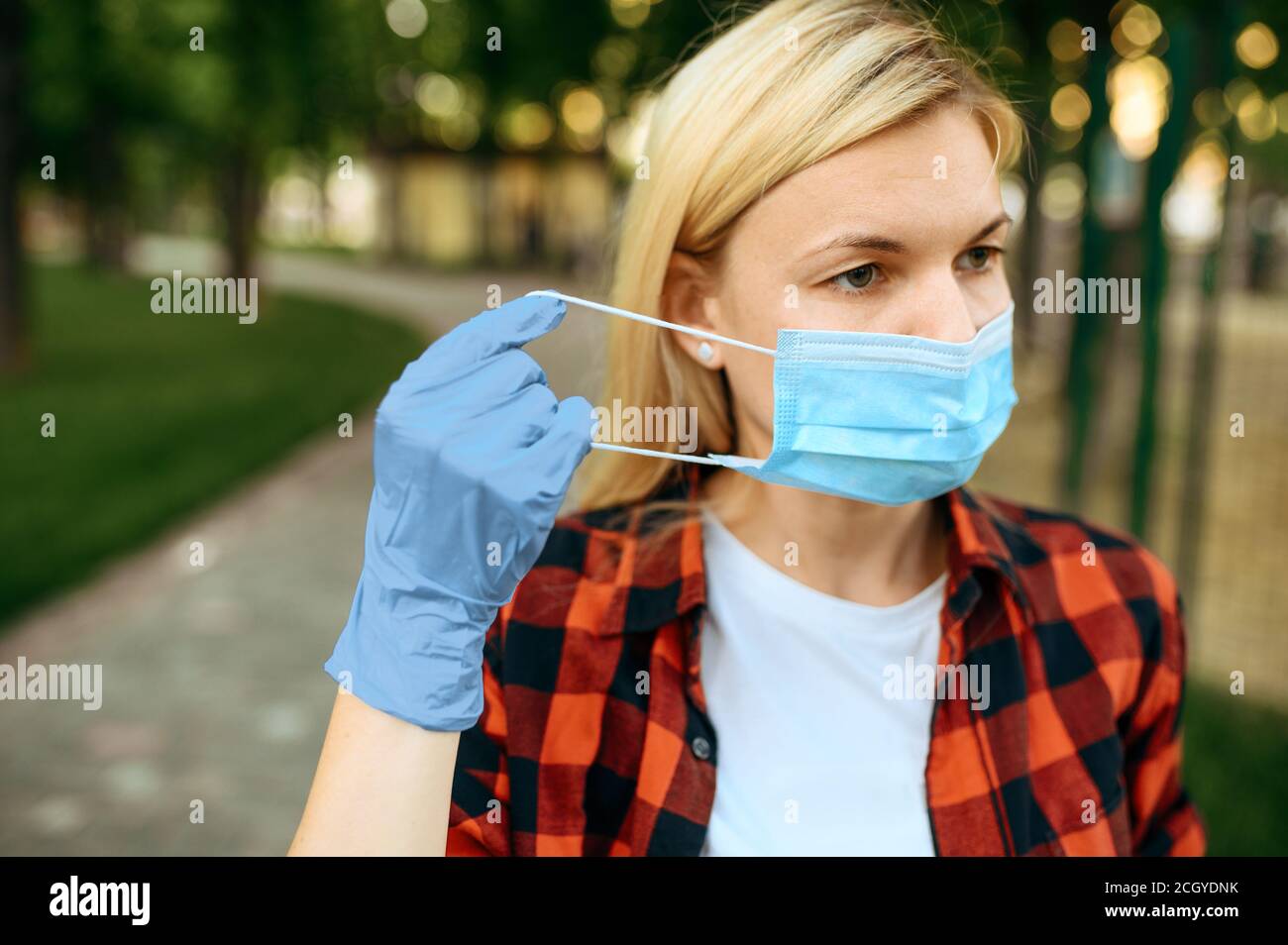 Woman puts face mask hi-res stock photography and images - Alamy