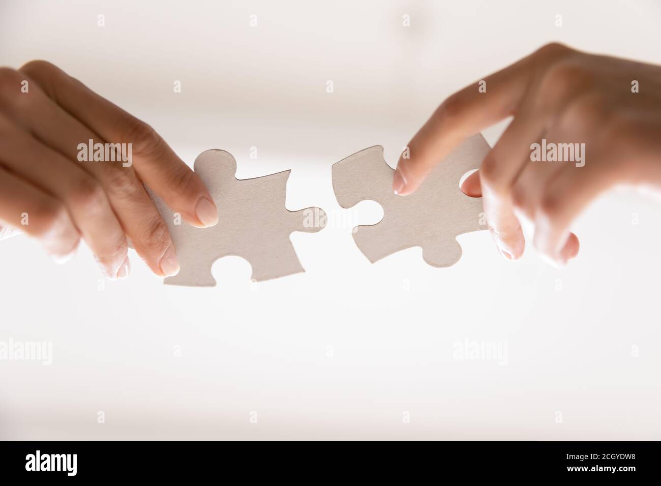 Close up of two people assemble jigsaw puzzle Stock Photo