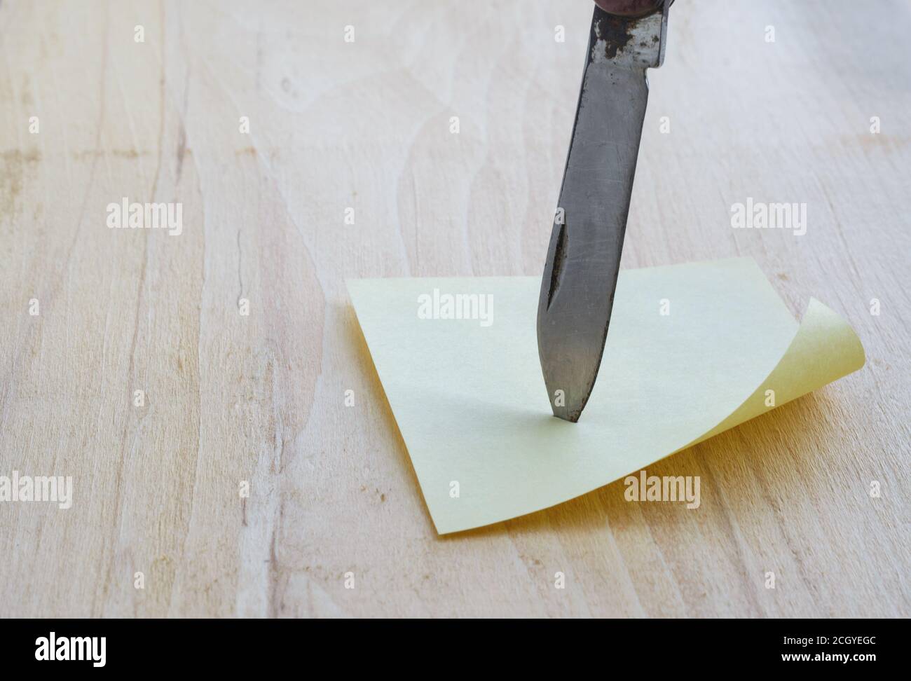 Sticker and the blade of a small knife on wooden background Stock Photo