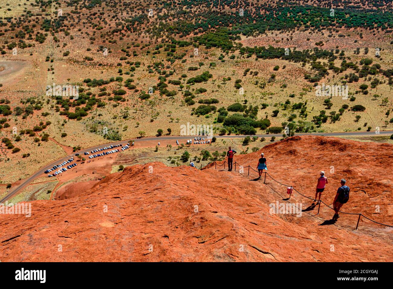 Tourist Climbing The Steep Cliffs Of The Red Mountain Massive Uluru Rock Ayers Rock Australia Stock Photo Alamy