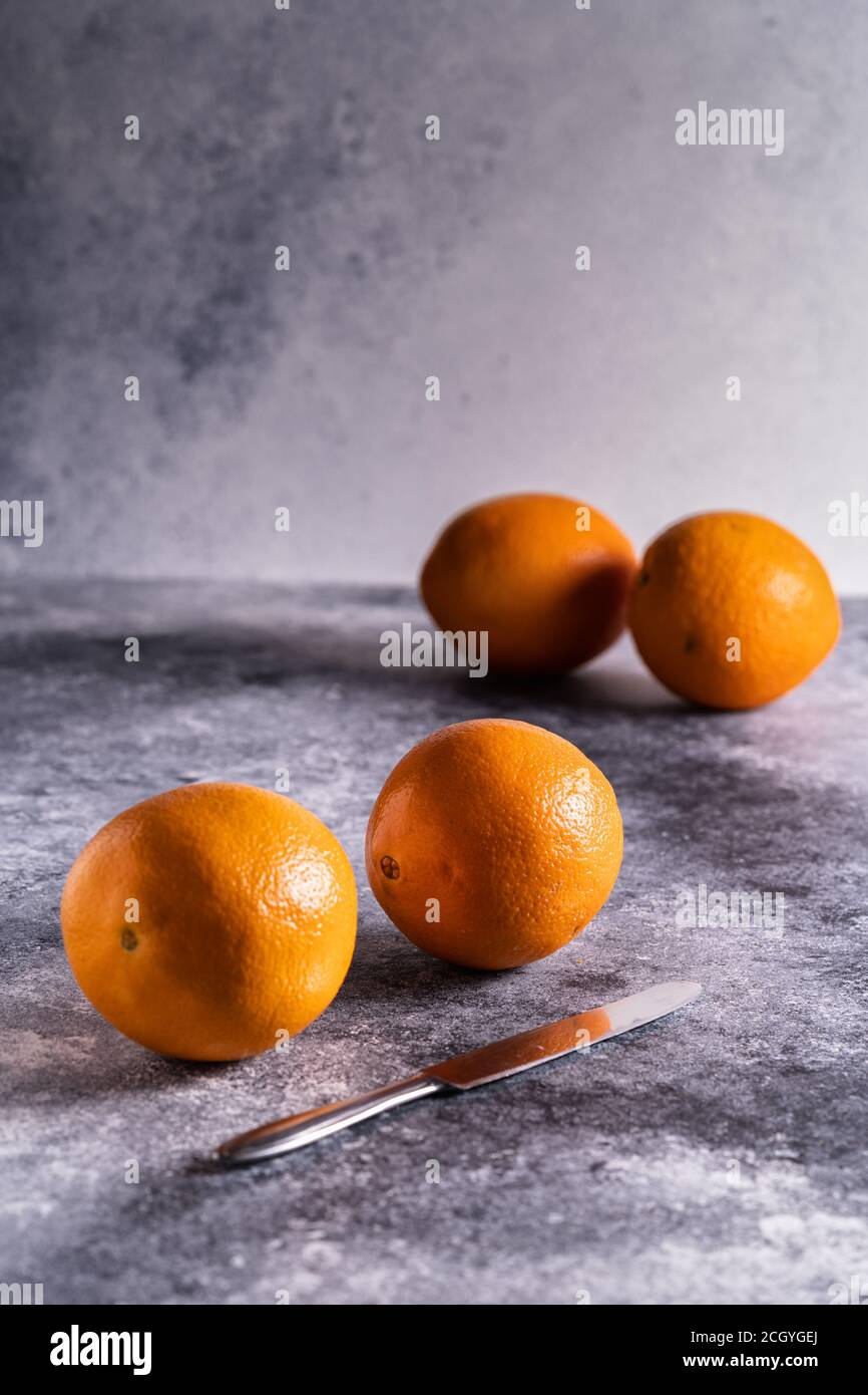 Fresh oranges on a gray concrete background, vertical. Stock Photo