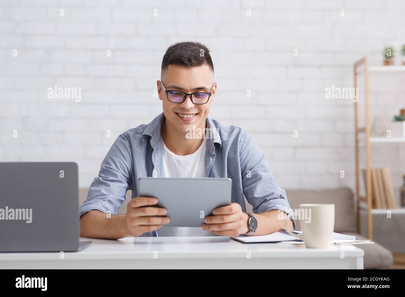 Modern hobbies and applications for home. Smiling guy with laptop looks