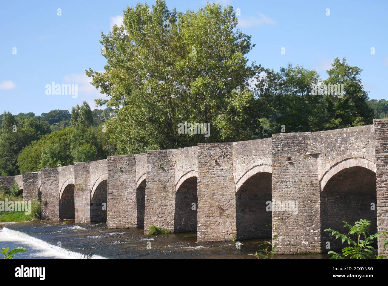 The grade 1 listed 18th century bridge, standing above a weir, across the River Usk, Crickhowell, Powys, Wales, United Kingdom Stock Photo