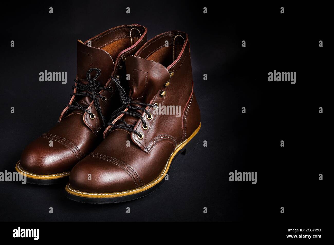 High boots. Fashionable mens leather brown shoes on black background
