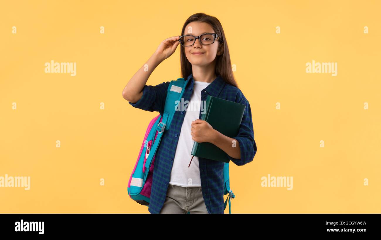 Smiling girl holding textbook at studio background Stock Photo - Alamy