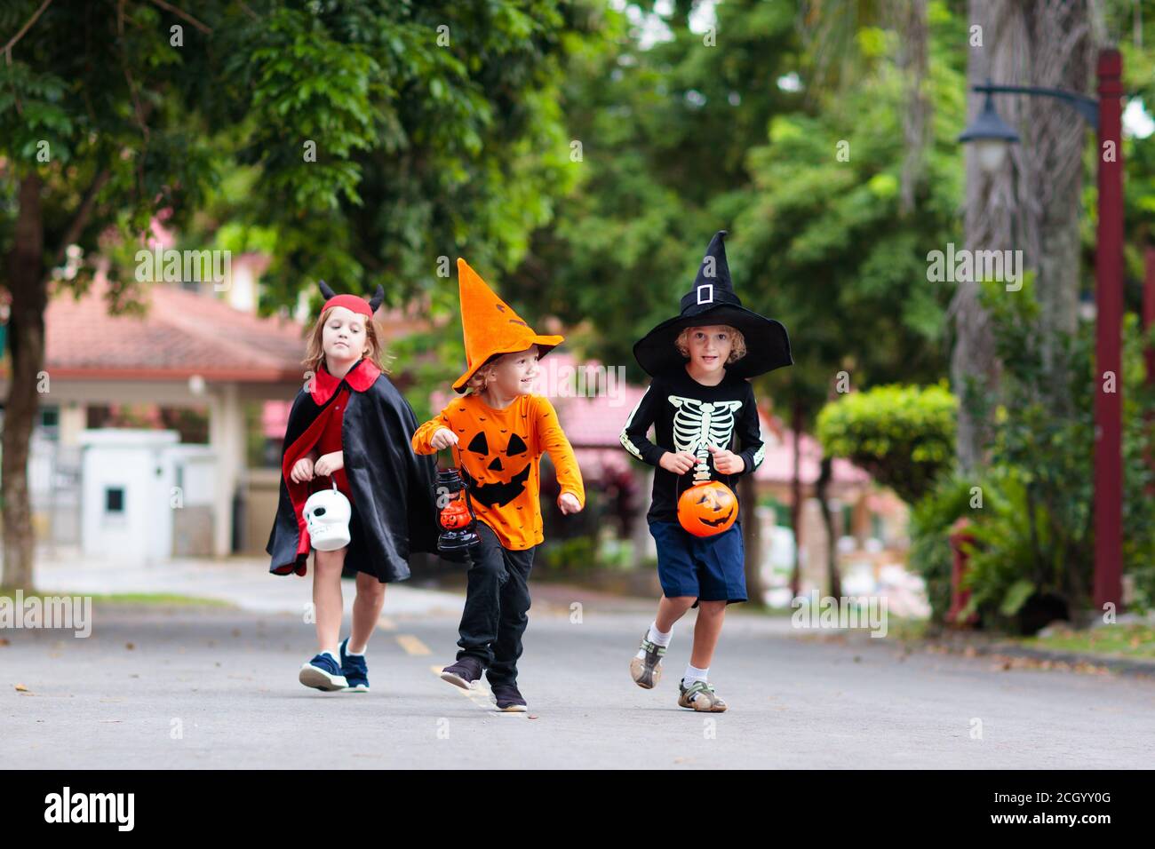 Child in Halloween costume. Kids trick or treat on suburban street ...
