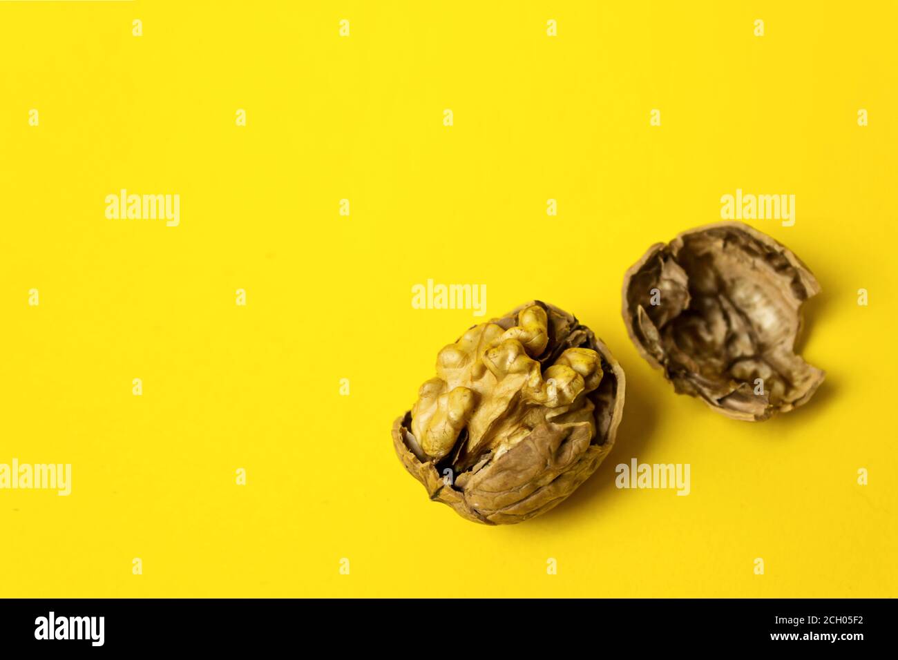 Cracked Walnut On Yellow Background. Close-Up, copy space Stock Photo