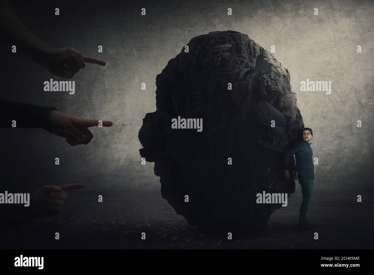 Scared businessman hiding behind a huge boulder, feels discomfort as people hands pointing to him blaming as guilty. High tension, person under pressu Stock Photo