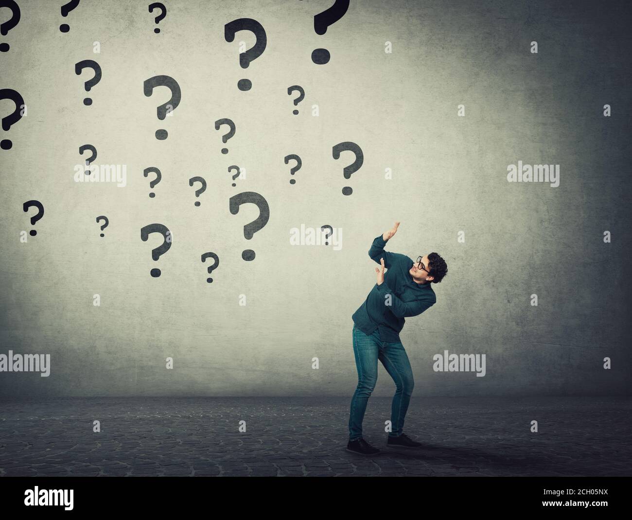 Scared man keeps hands raised up to protect him from multiple questions